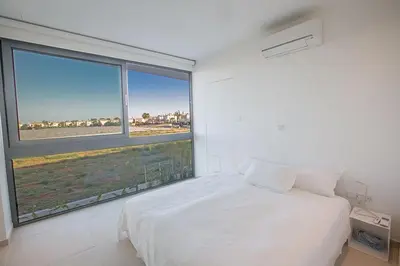 a bedroom with a white bed and a large window at Villa Limni Enas - Luxury And Contemporary 3 Bedroom Kapparis Villa With Sea View in Paralimni