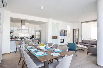 a dining room and living room with a table and chairs at Villa Olive Titan, Brand New,Exquisite 5Bdr Protaras Villa With Pool in Protaras