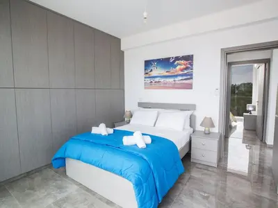 a bedroom with a bed with a blue blanket at Villa Olive Bronze, Luxurious 2Bdr With Pool, Close To Protaras Strip And Beach in Protaras