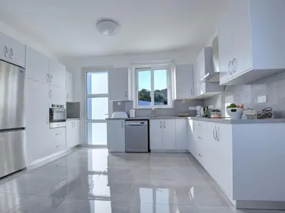 a large white kitchen with white cabinets and appliances at Villa Kono Provoles - Luxury 4 Bedroom Protaras Villa With Stunning Panoramic in Protaras