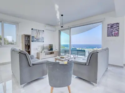 a living room with two chairs and a large window at Villa Kono Provoles - Luxury 4 Bedroom Protaras Villa With Stunning Panoramic in Protaras