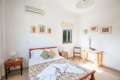 a bedroom with a bed and a table and a window at Villa Kanthos - Beautiful 4 Bedroom Protaras Villa With Pool in Protaras