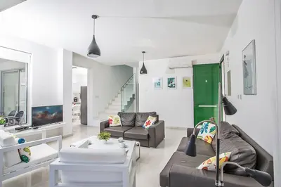 a living room with two couches and a green door at Villa Ochosto Selene - Stunning 5 Bedroom Protaras Villa With Private Pool in Protaras