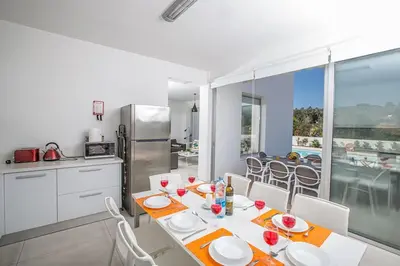 a kitchen and dining room with a table and chairs at Villa Ochosto Selene - Stunning 5 Bedroom Protaras Villa With Private Pool in Protaras