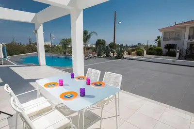 a white table and chairs on a patio at Villa Protara Chrysos - Beautiful 5 Bedroom Protaras Villa - Walking Distance in Protaras