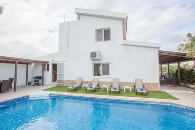 a villa with a swimming pool in front of a house at Villa Kavo Sunshine - Beautiful 3 Bedroom Protaras Villa With Private Pool in Protaras