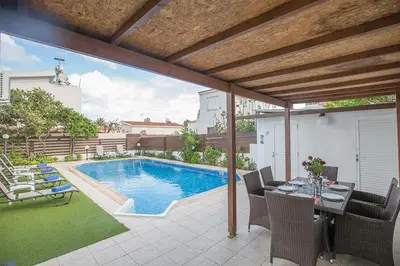 a patio with a pool and a table and chairs at Villa Kavo Sunshine - Beautiful 3 Bedroom Protaras Villa With Private Pool in Protaras