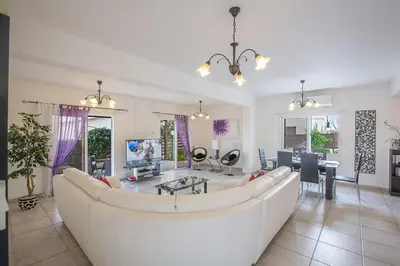 a living room with a white couch and a table at Villa Kavo Sunshine - Beautiful 3 Bedroom Protaras Villa With Private Pool in Protaras