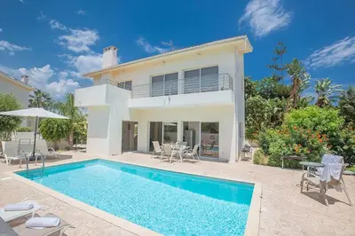 a villa with a swimming pool in front of a house at Central Protaras Villa 3 Bedrooms Private Pool Villa Dafnis Morfi in Protaras