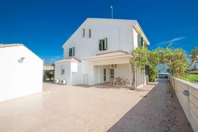 a white house with a fence next to it at Villa Matronas Titan - Stunning 5 Bedroom Protaras Villa With Private Pool in Paralimni