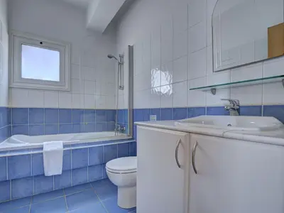 a blue and white bathroom with a toilet and a sink at Villa Oforo Selene - Stunning 4 Bedroom Villa - By Fig Tree Bay Beach - Sea View in Protaras