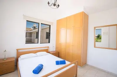 a bedroom with a bed with a blue pillow on it at Villa Protaras Eos, Modern 3Bdr Protaras Villa With Pool, Short Walk in Protaras