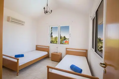 a bedroom with two beds and two windows at Villa Protaras Eos, Modern 3Bdr Protaras Villa With Pool, Short Walk in Protaras