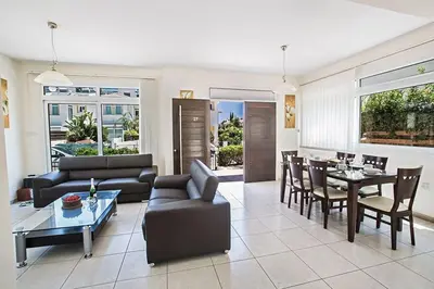 a living room with a couch and a table at Villa Dafnis Chrysos - Modern 3 Bedroom Protaras Villa With Pool in Protaras