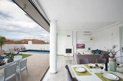 a living room and dining room with a table and chairs at Villa Olive Gold, Luxury And Brand New 2Bdr Protaras Villa With Private Pool in Protaras