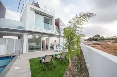 a house with two chairs and a swimming pool at Villa Olive Gold, Luxury And Brand New 2Bdr Protaras Villa With Private Pool in Protaras