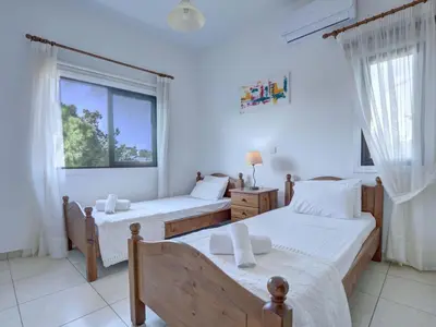 a bedroom with two beds and a large window at Villa Protaras Paralia Spacious 4Bdr Central Protaras Villa in Protaras