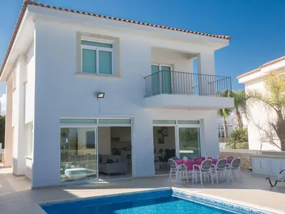 a villa with a swimming pool and a house at Villa Mesogi Seafront, Stunning 4Bdr Fontline Protaras in Protaras