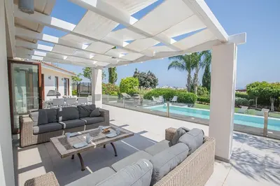 a patio with couches and a table and a pool at Villa Protaras Sunshine, Stylish 4Bdr Villa With Pool, Close To Fig Tree in Protaras