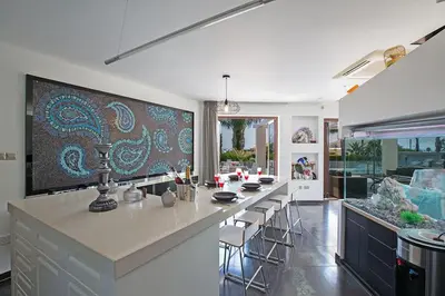 a kitchen with a large island with bar stools at Villa Protaras Sunshine, Stylish 4Bdr Villa With Pool, Close To Fig Tree in Protaras