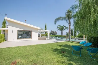 a yard with two chairs and a house at Villa Protaras Sunshine, Stylish 4Bdr Villa With Pool, Close To Fig Tree in Protaras