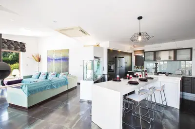 a kitchen and living room with a couch and a table at Villa Protaras Sunshine, Stylish 4Bdr Villa With Pool, Close To Fig Tree in Protaras