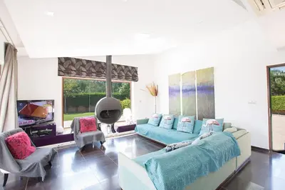a large living room with a blue couch and chairs at Villa Protaras Sunshine, Stylish 4Bdr Villa With Pool, Close To Fig Tree in Protaras