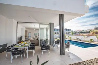an open living room with a table and chairs at Villa Olive Chrysos, Brand New, Luxury 3 Bdr Protaras Villa, With Private Pool in Protaras