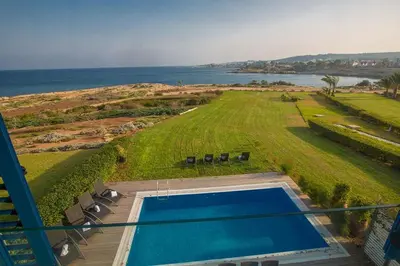 an overhead view of a swimming pool and the ocean at Villa Fig Tree Bay Frontline,Luxury 4Bdr Sea-Front Protaras Villa With Pool in Protaras