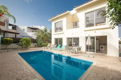 a swimming pool in front of a house at Villa Dafnis Sunshine - Modern 3 Bedroom Central Protaras Villa With Pool in Protaras