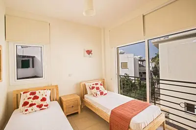 a bedroom with two beds and a large window at Villa Dafnis Sunshine - Modern 3 Bedroom Central Protaras Villa With Pool in Protaras