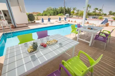 a table and chairs next to a swimming pool at Villa Akefalo - Beautiful 3 Bedroom Protaras Villa With Private Pool in Protaras