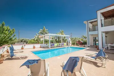 a villa with a swimming pool with chairs and a house at Villa Akefalo - Beautiful 3 Bedroom Protaras Villa With Private Pool in Protaras