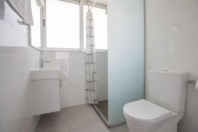 a white bathroom with a toilet and a window at Villa Ochosto Helios - Beautiful 5 Bedroom Protaras Villa - Walking Distance in Protaras