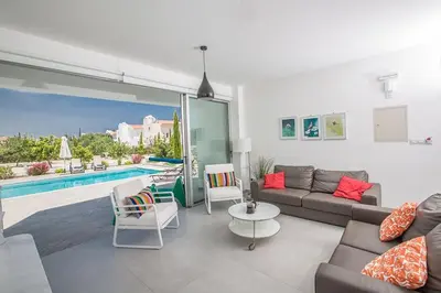 a living room with a couch and a table and a pool at Villa Ochosto Helios - Beautiful 5 Bedroom Protaras Villa - Walking Distance in Protaras