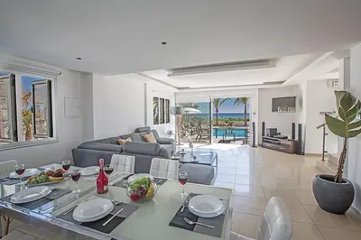 a living room with a table and a couch at Villa Adaman - Stunning 3 Bedroom Seafront Villa With Pool - Close To The Beach in Ayia Napa