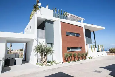 a large white house with a red brick at Villa Papadopo - Luxury 3 Bedroom Villa With Private Pool, Hot Tub And Sea Views in Paralimni