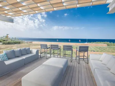 a patio with a couch and chairs and the ocean at Villa Papadopo - Luxury 3 Bedroom Villa With Private Pool, Hot Tub And Sea Views in Paralimni