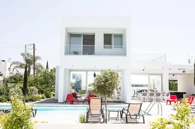 a white house with a pool and chairs at Villa Ochosto Chrysos - Stunning 5 Bedroom Protaras Villa - Close To Fig Tree in Protaras