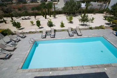 a swimming pool with lounge chairs and a beach at Villa Ochosto Chrysos - Stunning 5 Bedroom Protaras Villa - Close To Fig Tree in Protaras