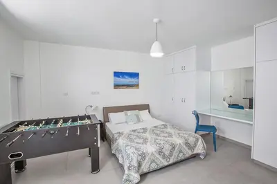 a bedroom with a bed and a table in a room at Villa Ochosto Chrysos - Stunning 5 Bedroom Protaras Villa - Close To Fig Tree in Protaras