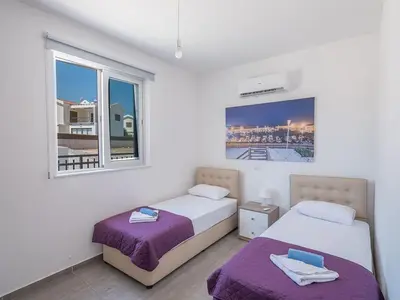 two beds in a white room with a window at Villa Protaras Miramar, Luxury And New 5Bdr Protaras Villa With Pool in Protaras