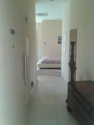a room with a bedroom with a bed in the background at Pallini Court in Protaras