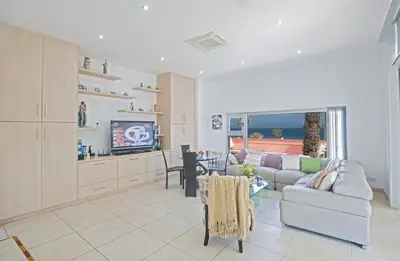 a living room with a couch and a tv at Pallini Court in Protaras