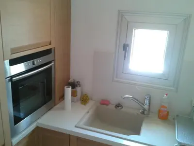 a small kitchen with a sink and a window at Pallini Court in Protaras