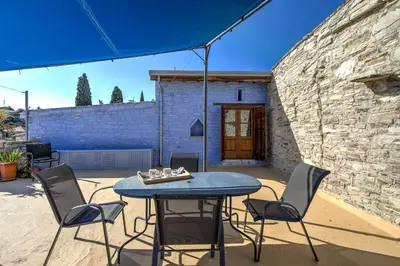 a patio with a table and chairs and an umbrella at Blue Oak House in Kato Drys