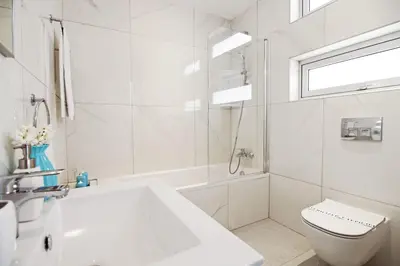 a white bathroom with a tub and a toilet and a sink at Villa Nova in Protaras