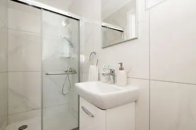 a white bathroom with a sink and a shower at Villa Nova in Protaras