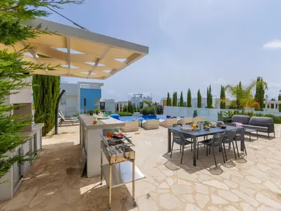a patio with a table and chairs on a roof at Milos lifestyle villas H27 in Protaras