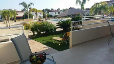 a balcony with a view of a pool at Nissi 3 Pool Access Garden Apartment in Ayia Napa